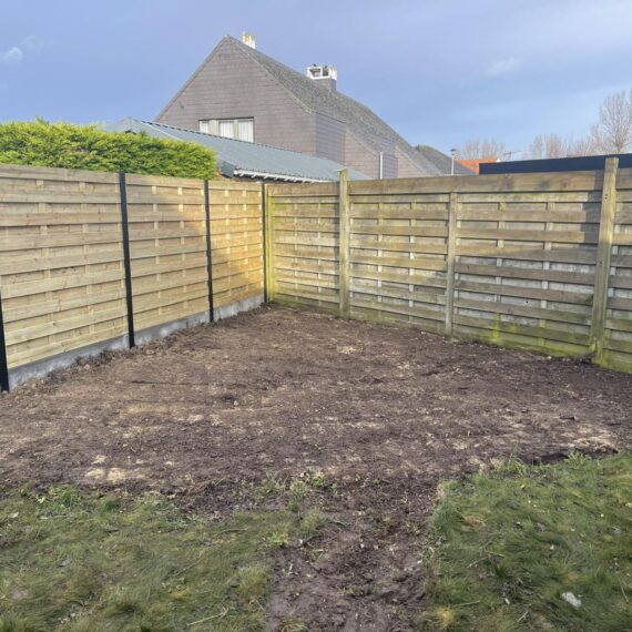 Plaatsen van omheining met betonplint en zwarte aluminium palen te Middelkerke