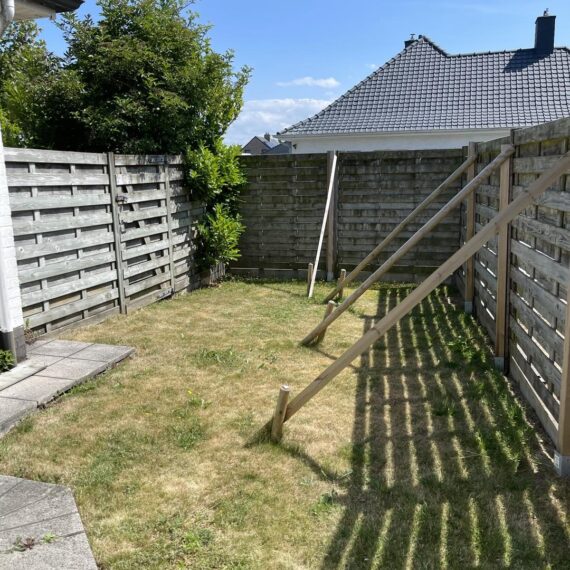 Plaatsen van omheining met betonplint en zwarte aluminium palen te Middelkerke